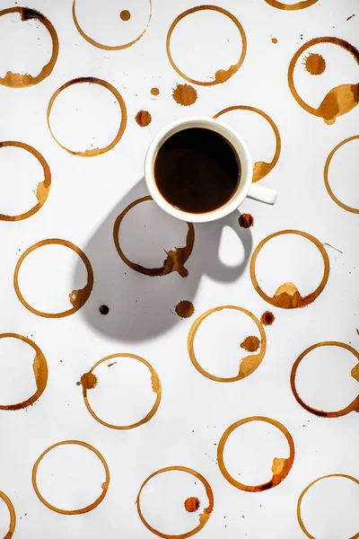 Tasse schwarzen Kaffee auf einer Oberfläche mit vielen Kaffeeflecken. — Stockfoto