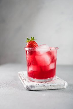 Gri arka planda buz ile srawberry soda içecek.