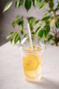 Limon ve buz küpleri ile masada plastik fincan soda ile buz limonata. İçecek içeceği.