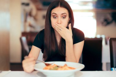 Woman Feeling Sick While Eating Bad Food in a Restaurant clipart