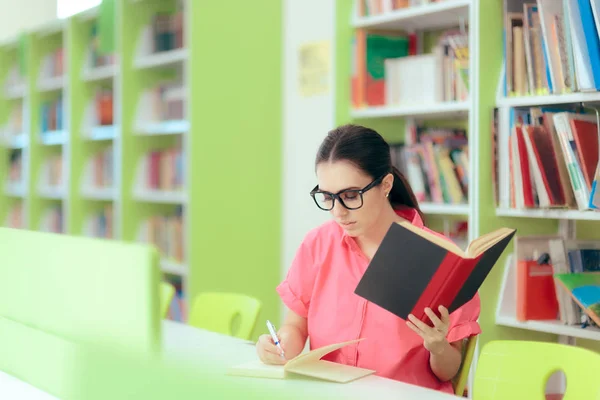 Kvinnlig Student Skriver Uppsats Uppdrag Skolans Bibliotek — Stockfoto