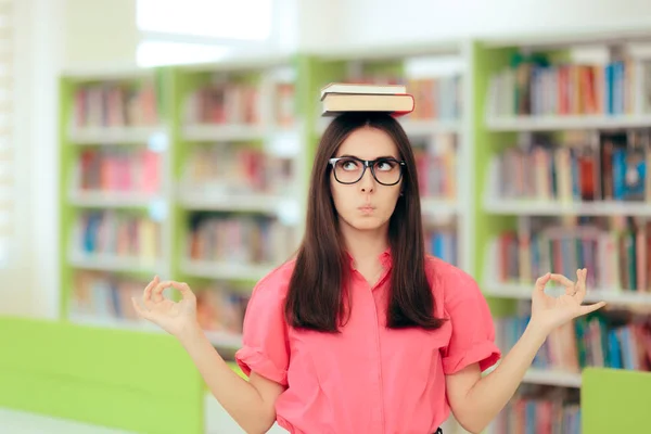 滑稽的学生平衡书在她的头在图书馆里 — 图库照片