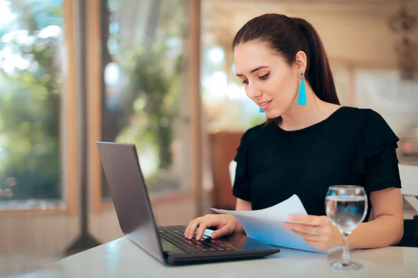 Woman Reading Important Document While Typing Laptop — Stock Photo, Image