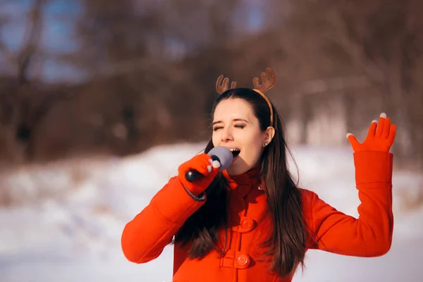 冬の屋外のキャロルを歌うクリスマスの女の子 — ストック写真
