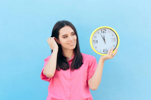 青色の背景に時計を保持している陽気な女性 — ストック写真