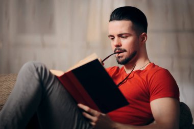 Yakışıklı adam ev ve rahatlatıcı bir kitap okuma
