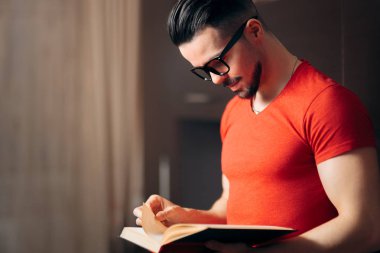 Yakışıklı adam ev ve rahatlatıcı bir kitap okuma