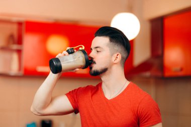 Sağlıklı adam mutfakta bir Protein Shake içmeye uygun