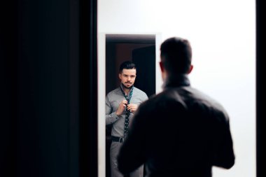 Şık adam kendini aynada kıyafetlere kontrol