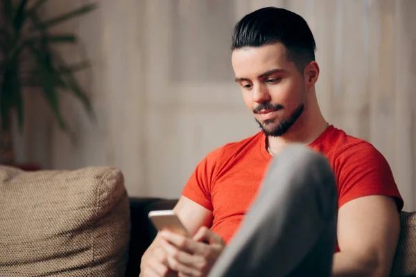 Homem Segurando Smartphone Relaxando Sofá Casa — Fotografia de Stock