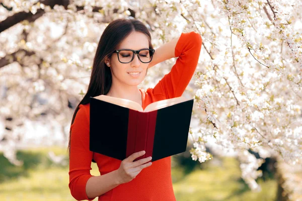 Kadın Çiçek Açan Bir Ağacın Altında Bir Kitap Okuma — Stok fotoğraf