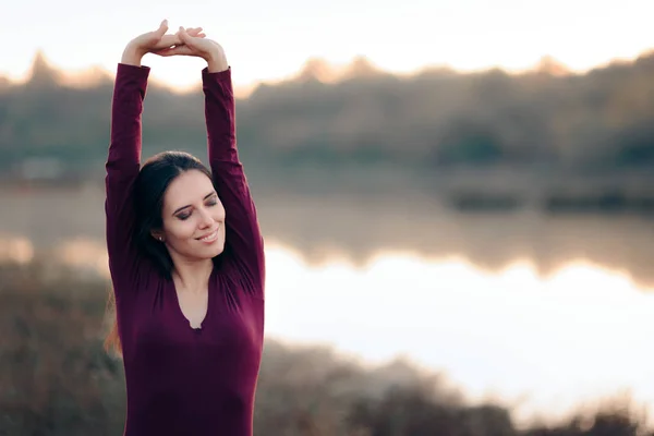 湖の前で腕を伸ばす女性 — ストック写真