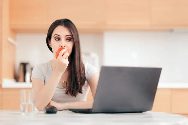 Donna Che Mangia Una Mela Mentre Lavora Sul Computer Portatile — Foto Stock