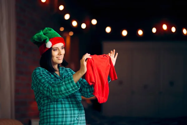Roztomilá Těhotná Žena Slaví Vánoce Držení Dětské Oblečení — Stock fotografie