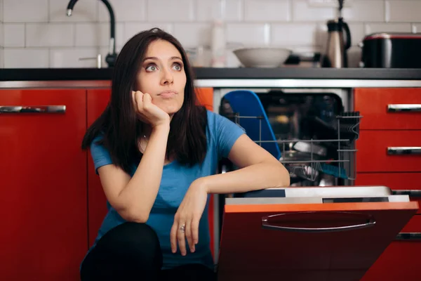 完全食器洗い機のクリーニングキッチンの隣に悲しい疲れの女性 — ストック写真