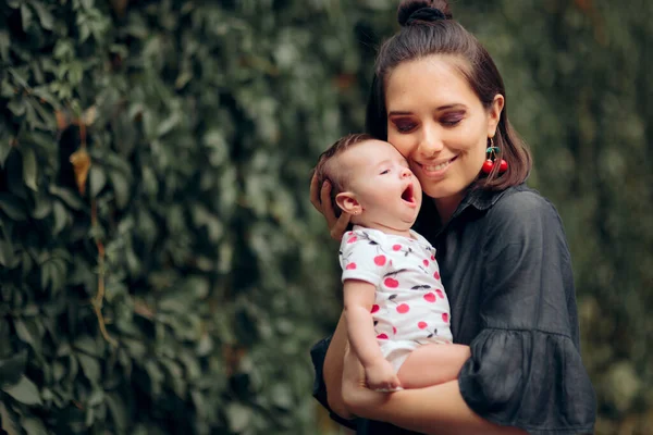 Happy Mom Holding Funny Sleepy Yawning Baby