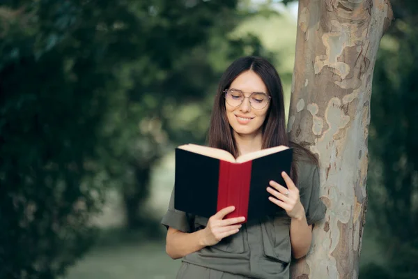 Όμορφη Γυναίκα Γυαλιά Διαβάζοντας Ένα Βιβλίο Στη Φύση — Φωτογραφία Αρχείου