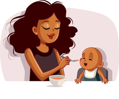 Afrikalı anne bebeğini kaşıkla katı gıdayla besliyor.