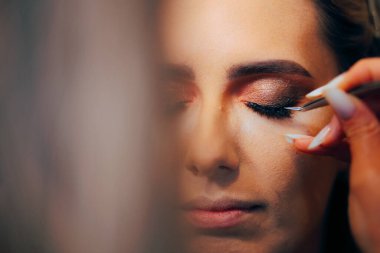 Kirpiklerini cımbızla süren Profesyonel Makyaj Sanatçısı 