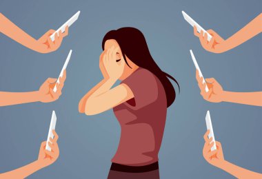 İnsanlar cep telefonlarını yüzünü saklayan bir kıza doğrultuyor.