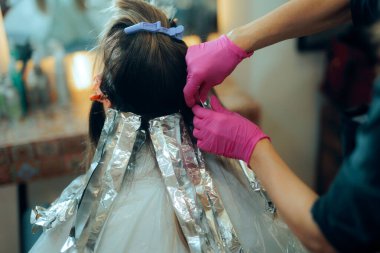 Kuaför alüminyum folyoyla Balayage tekniği yapıyor.