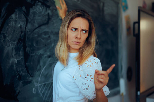 Разъяренный учитель вытирает доски, указывая на учеников