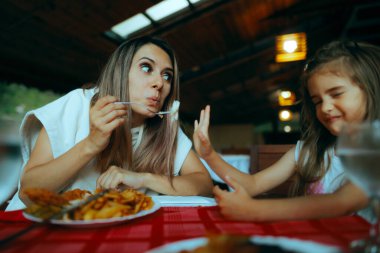 Anne çocuğunu beslemeye çalışıyor. Yemeği reddediyor.