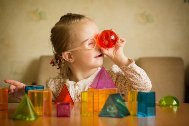 Down sendromlu geometrik şekillerle oynayan kız