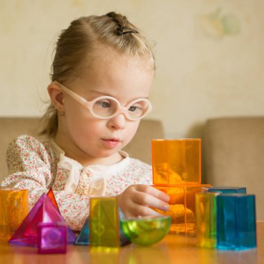 Down sendromlu geometrik şekillerle oynayan kız