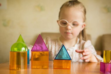 Down sendromlu geometrik şekillerle oynayan kız