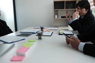 Toplantı salonunun içinde smartphone kullanarak iş adamı. ofiste cep telefonu tutan adam