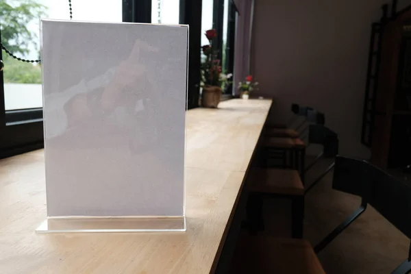 white label in cafe. display stand for acrylic tent card in coffee shop. mockup menu frame on table in bar restaurant. space for text