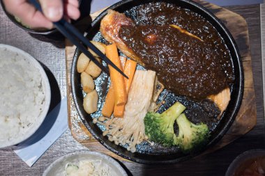 havuç tutarak yemek çubukları. Barbekü balık fileto, sos ve ızgara sebze. Japon gıda Restoran