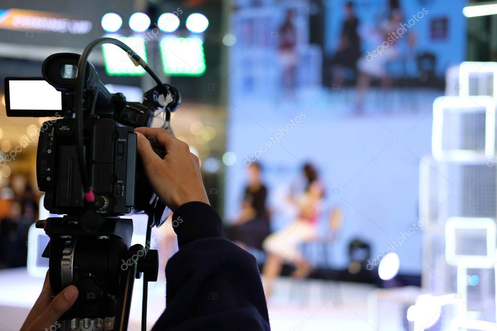 professional video production camera recording live event on stage. television social media broadcasting seminar conference.
