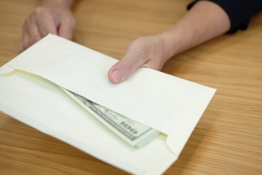 Zarf para banknot ile sunan bir kadın. nakit banknot - rüşvet, yolsuzluk, yiyicilik kavramı veren el