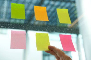 el cam duvar işyerinde yapışkan notlar tutun. Yaratıcı fikir ve iş beyin fırtınası için yapışkan not kağıt hatırlatma programı