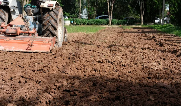 farmer in tractor preparing field for seedling. agriculture work at farm land