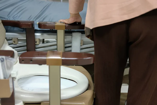 老年妇女在医院病人病床附近使用手提移动塑料马桶 — 图库照片