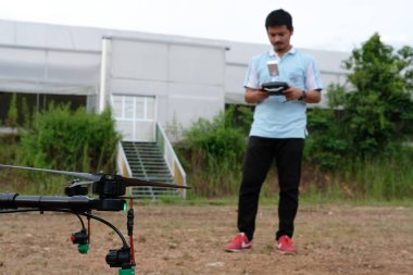 Chiang Mai, Tayland - 7 Eylül 2018: adam Maejo Üniversitesi'nde arazi üzerinde sıvı gübre püskürtme için tarım dron kontrol.