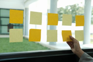 el cam duvar işyerinde yapışkan notlar tutun. Yaratıcı fikir ve iş beyin fırtınası için yapışkan not kağıt hatırlatma programı