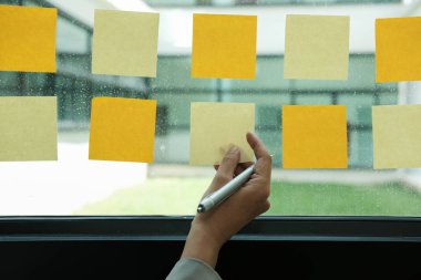 el cam duvar işyerinde yapışkan notlar tutun. Yaratıcı fikir ve iş beyin fırtınası için yapışkan not kağıt hatırlatma programı