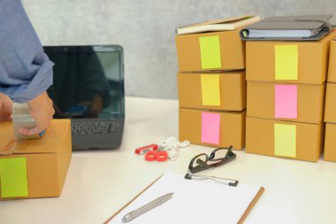 İşyerinde karton kutu ambalaj başlangıç küçük işletme sahibi. serbest kadın girişimci satıcı parsel kutusu, ürünün müşteriye teslim için hazırlayın. Online satış, e-ticaret kavramı