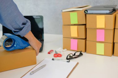 İşyerinde karton kutu ambalaj başlangıç küçük işletme sahibi. serbest kadın girişimci satıcı parsel kutusu, ürünün müşteriye teslim için hazırlayın. Online satış, e-ticaret kavramı