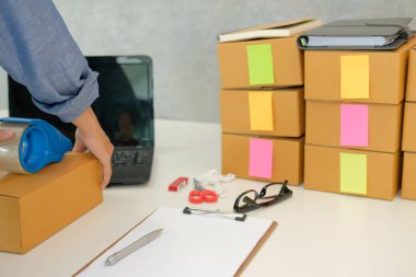 İşyerinde karton kutu ambalaj başlangıç küçük işletme sahibi. serbest kadın girişimci satıcı parsel kutusu, ürünün müşteriye teslim için hazırlayın. Online satış, e-ticaret kavramı