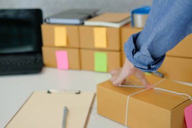 İşyerinde karton kutu ambalaj başlangıç küçük işletme sahibi. serbest kadın girişimci satıcı ürün parsel kutusu müşteriye teslim için hazırlayın. Online satış, e-ticaret kavramı