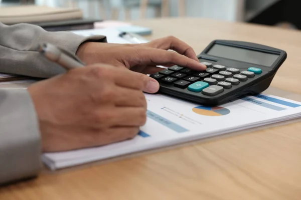 financial adviser working with calculator, business document at office. accountant doing accounting & calculating revenue & budget. bookkeeper making calculation. finance & economy concept