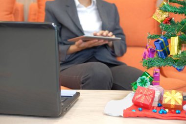 tablet kullanarak koltukta oturan adam. işkadını manifatura touchpad xmas sırasında iletide. Noel tatil yeni yıl kutlama Sezon selamlar