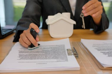 Emlakçı ile ev anahtar stamper damgalama için kullanarak ipotek kredi sözleşmesi sözleşme belge üzerinde onaylı