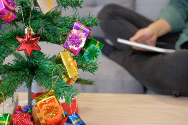 evde tablet kullanarak koltukta oturan adam. kadın holding touchpad xmas sırasında. Noel tatil yeni yıl kutlama Sezon selamlar