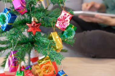 evde tablet kullanarak koltukta oturan adam. kadın holding touchpad xmas sırasında. Noel tatil yeni yıl kutlama Sezon selamlar